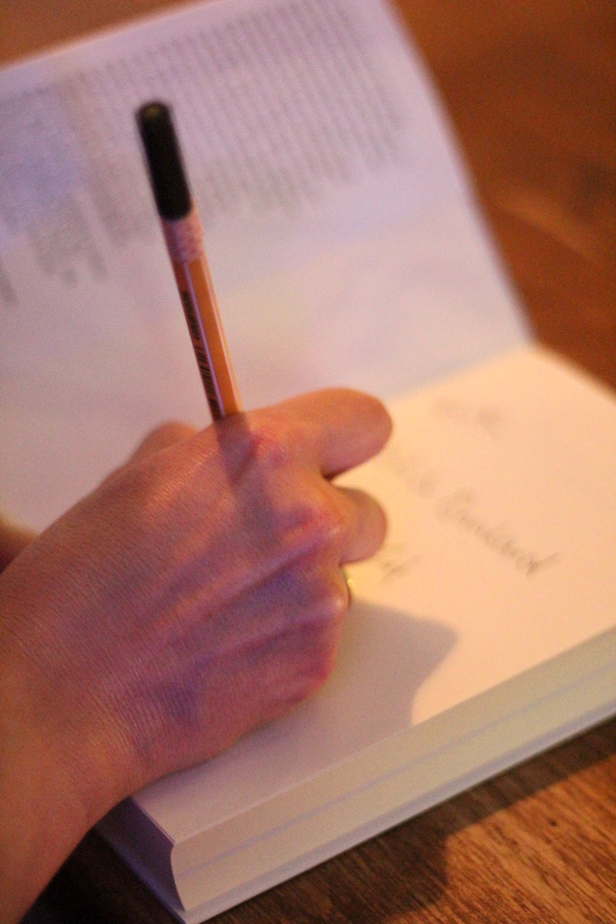 Shabnams Hand, die unser Buch signiert